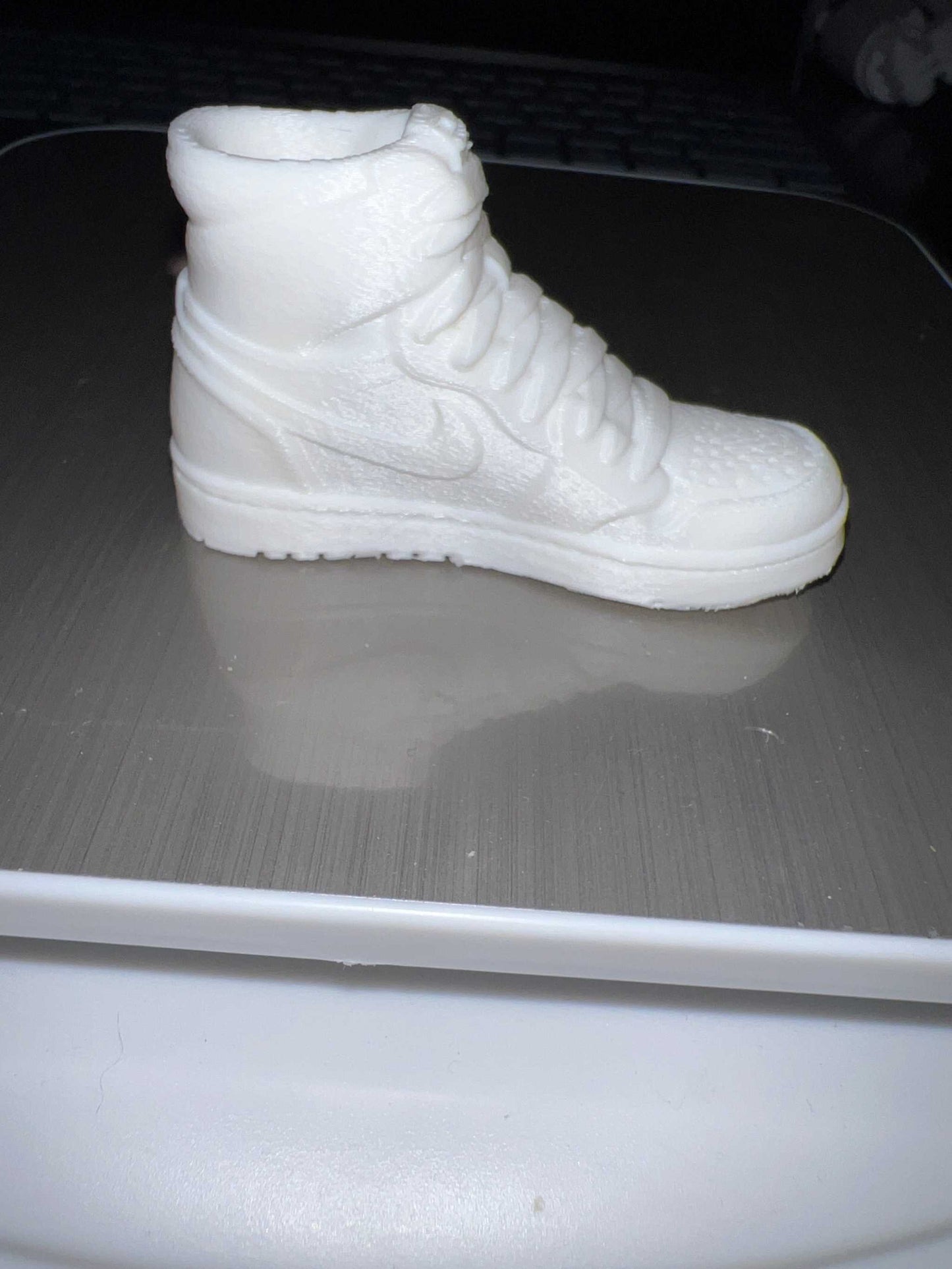 White miniature sneaker shoe lid topper keychain resembling a high-top sneaker.