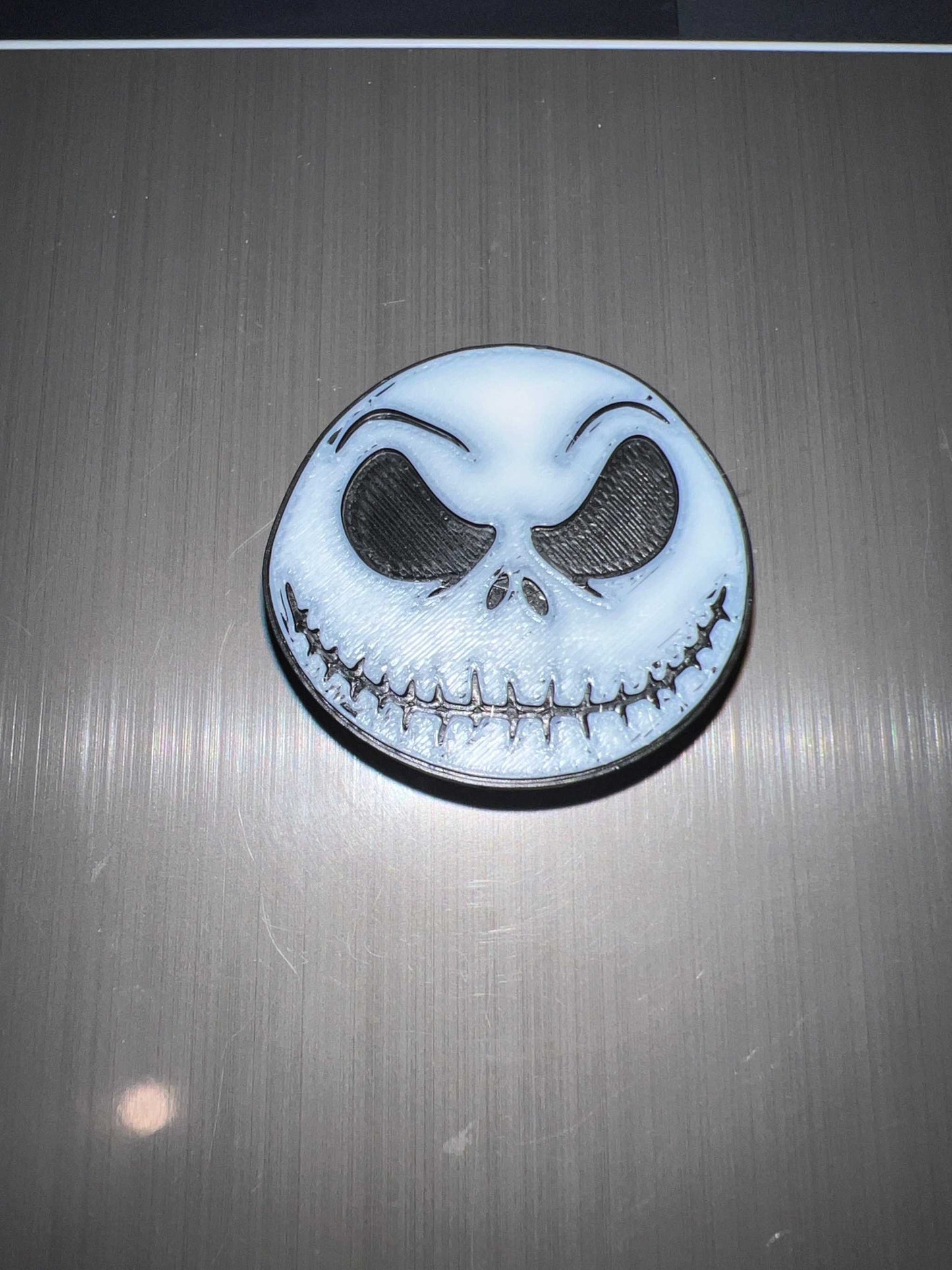 Skellington straw topper featuring a white skull face with black eyes and stitched smile design