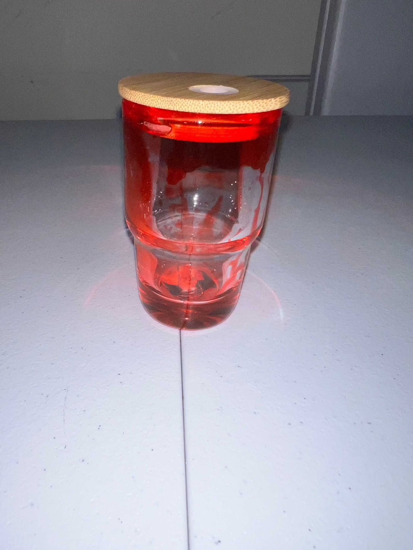 3oz shot glass with a wooden lid, on a white surface.