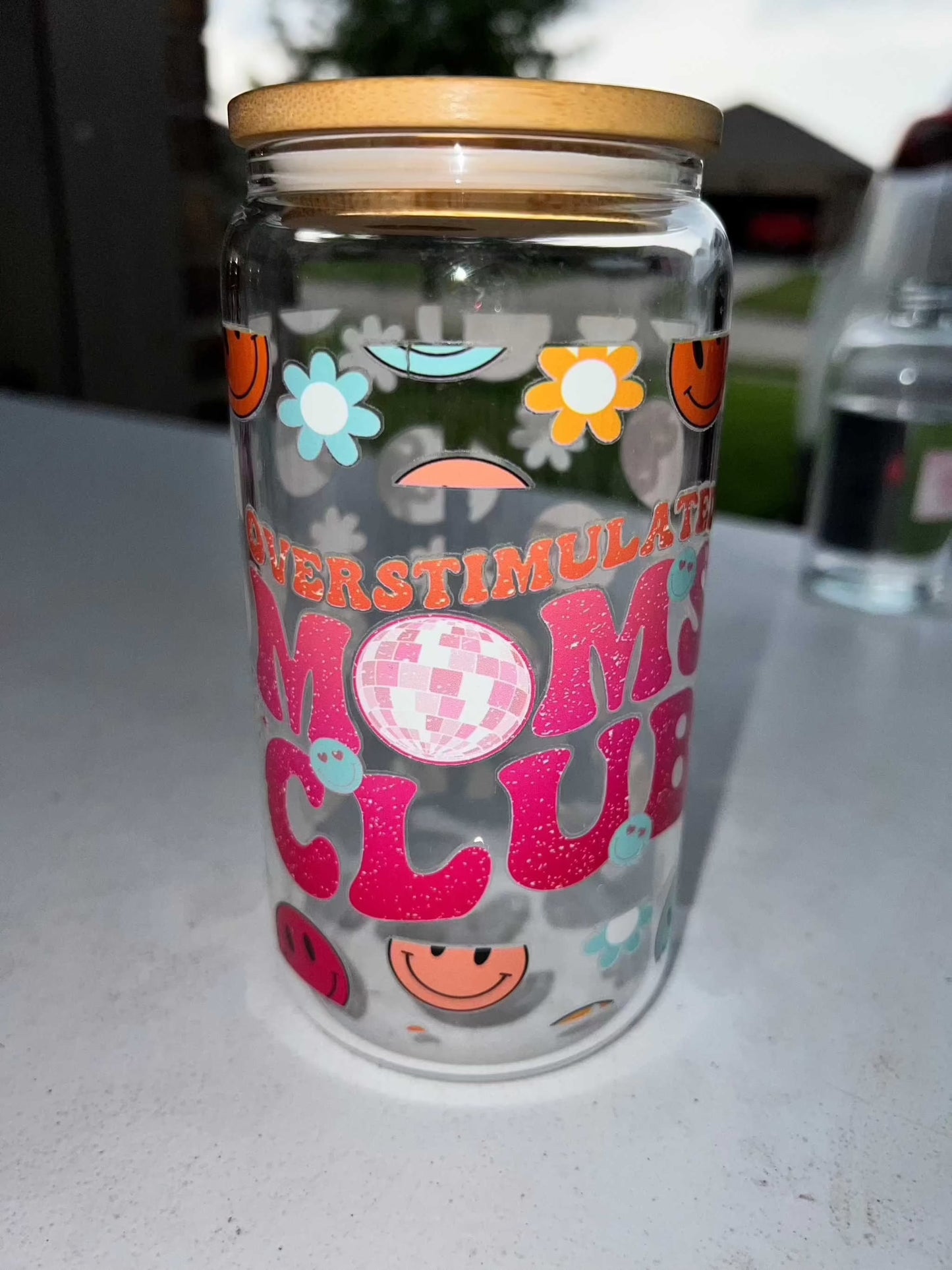 16oz clear glass cup with colorful design and wooden lid.