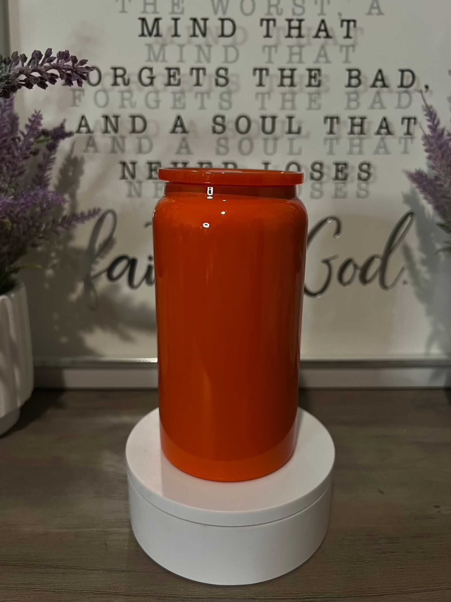 16oz glossy stainless steel tumbler with sleek, insulated design placed on a white stand.