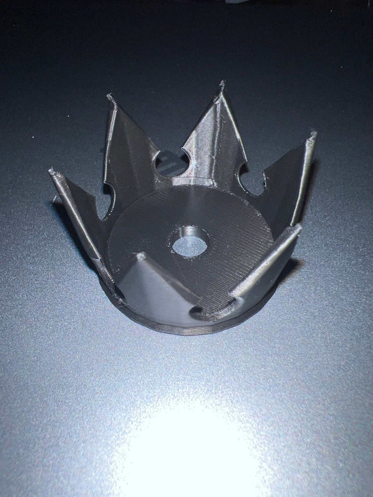 Black plastic crown-shaped straw topper with central hole for inserting straw