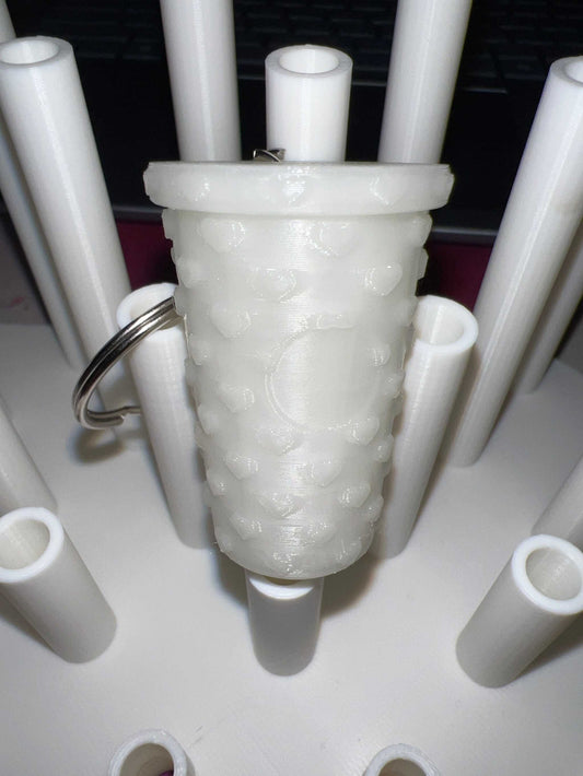 Glow in the dark tumbler shaped keychain with textured surface and attached metal ring
