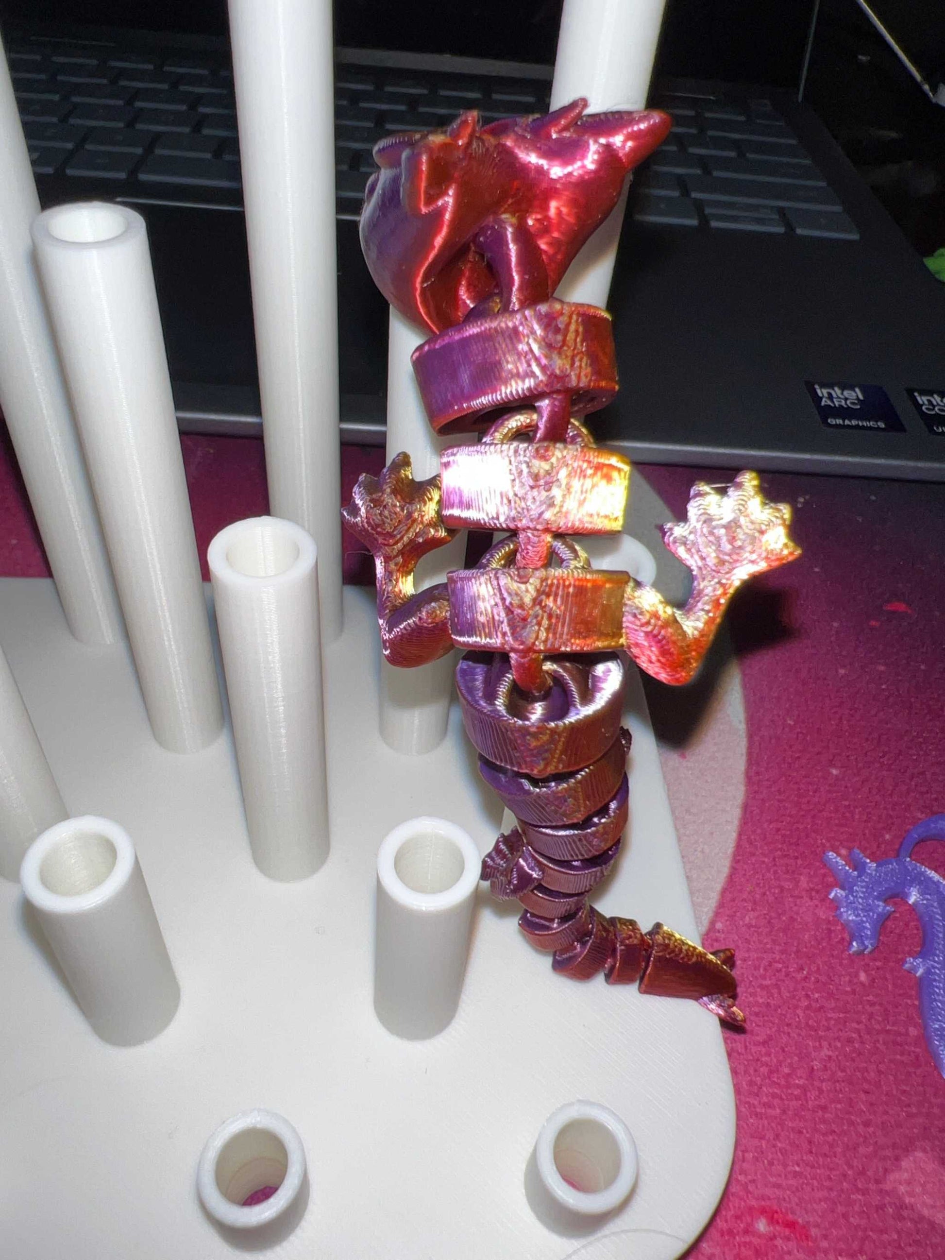 3D printed metallic red dragon straw topper wrapped around a white straw drying rack