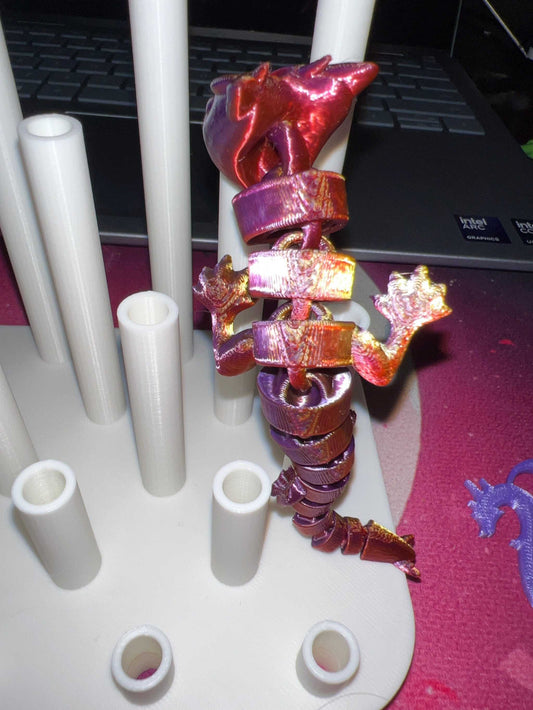 3D printed metallic red dragon straw topper wrapped around a white straw drying rack