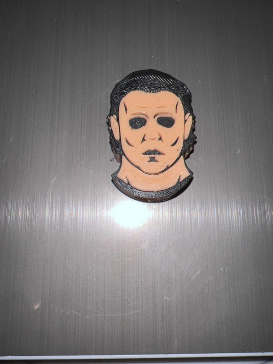 Meyers straw topper featuring a stylized face design on a metal surface