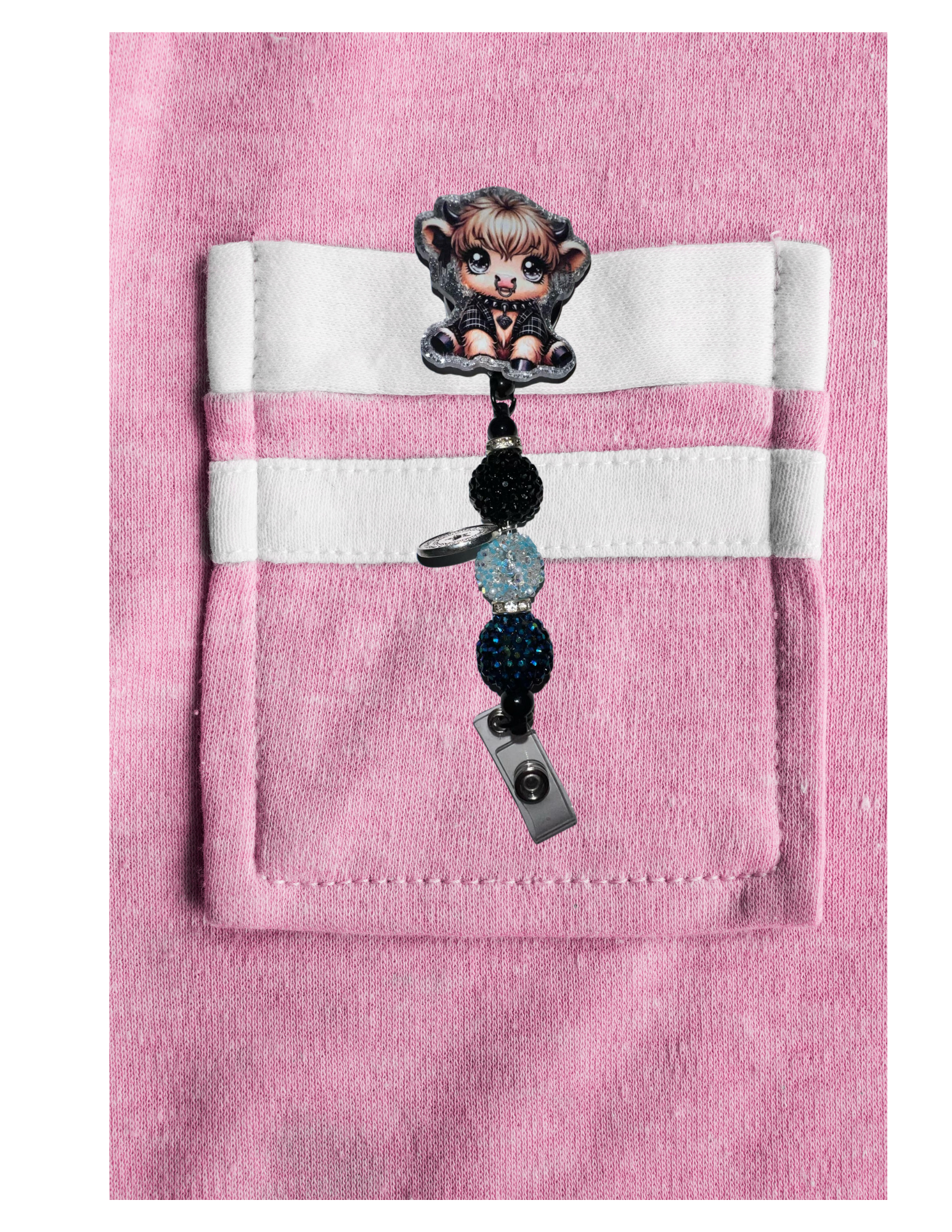 Handmade Acrylic Badge Reel on pink fabric with cartoon character design.