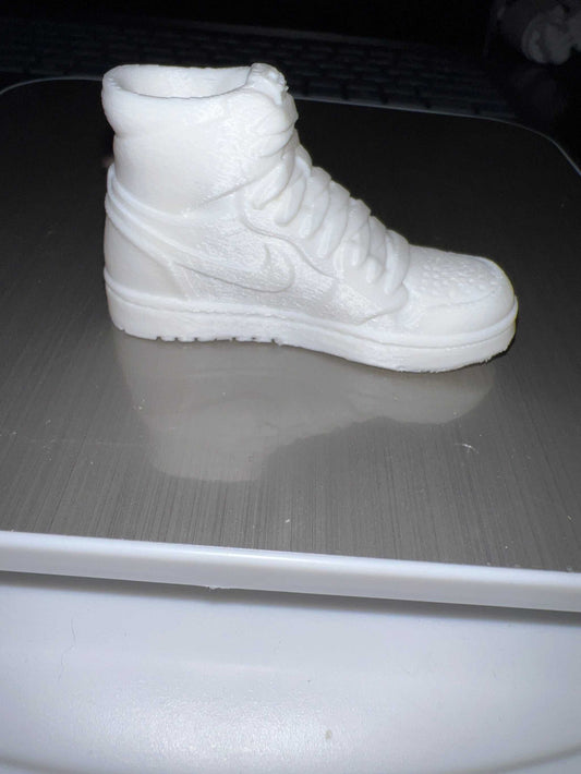 White miniature sneaker shoe lid topper keychain resembling a high-top sneaker.