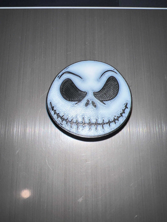 Skellington straw topper featuring a white skull face with black eyes and stitched smile design