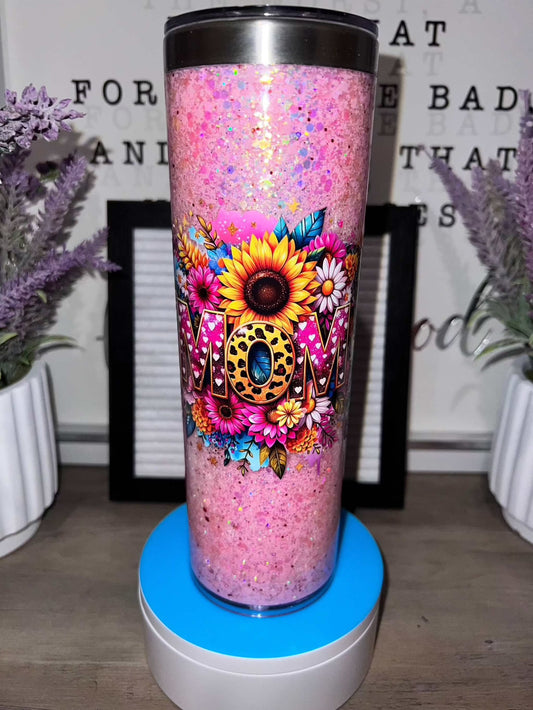 Pink glitter tumbler with floral design and "MOM" text.