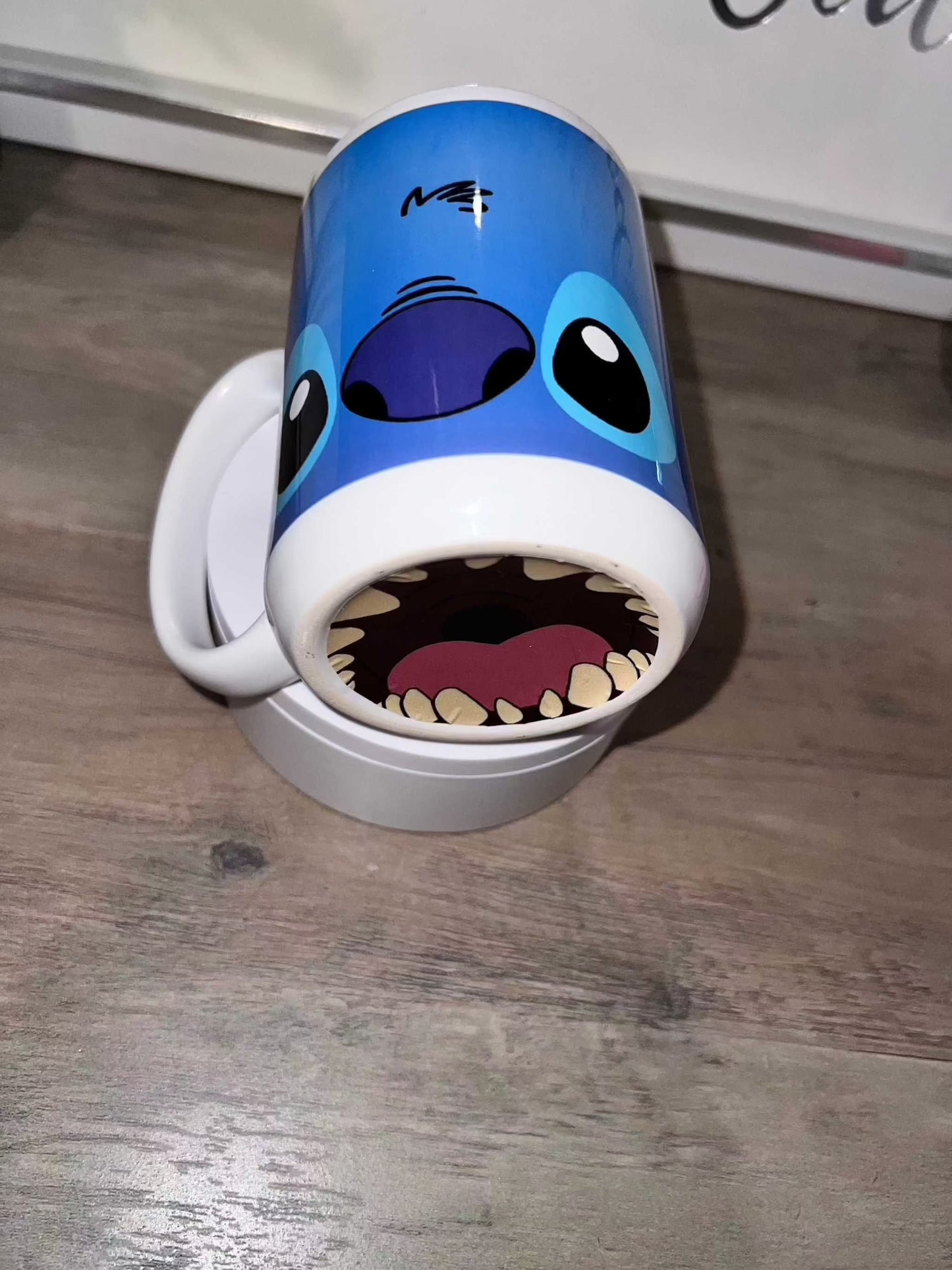 15oz ceramic mug with a cartoon design, featuring blue and white colors, placed on a wooden surface.