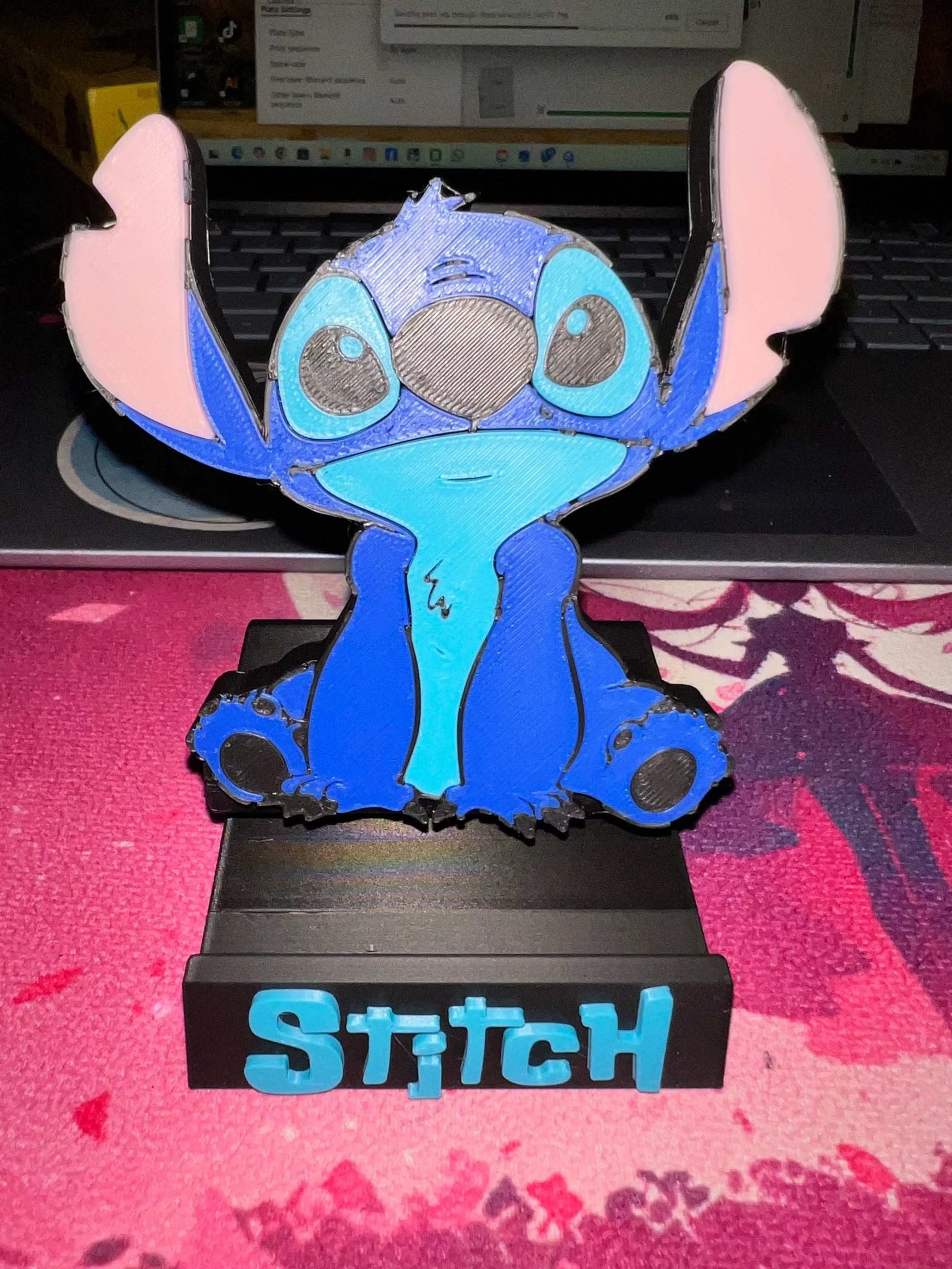 blue guy phone holder featuring Stitch character sitting on black base with blue text
