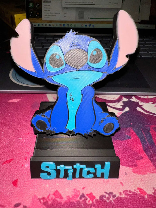 blue guy phone holder featuring Stitch character sitting on black base with blue text