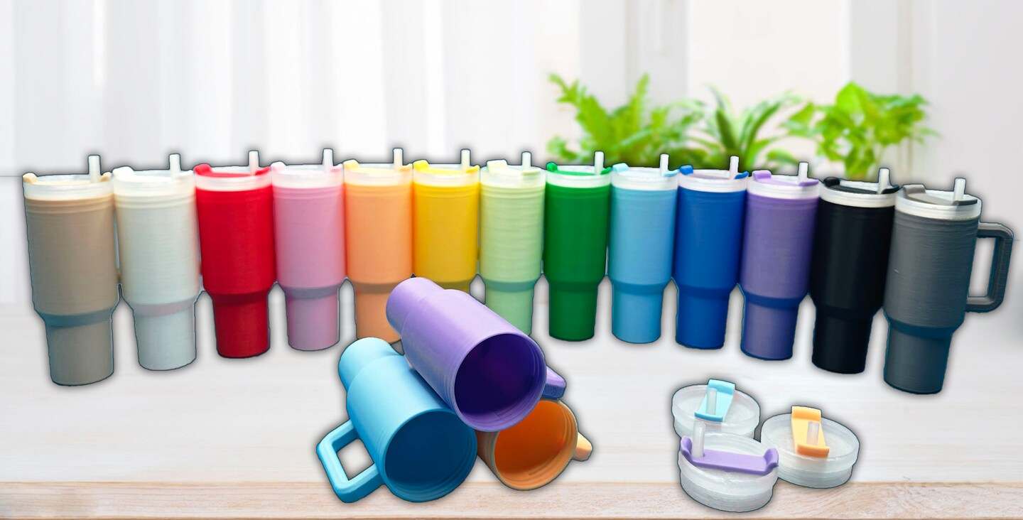 Colorful mini tumbler keychains with handles and storage compartment, lined up on a table.
