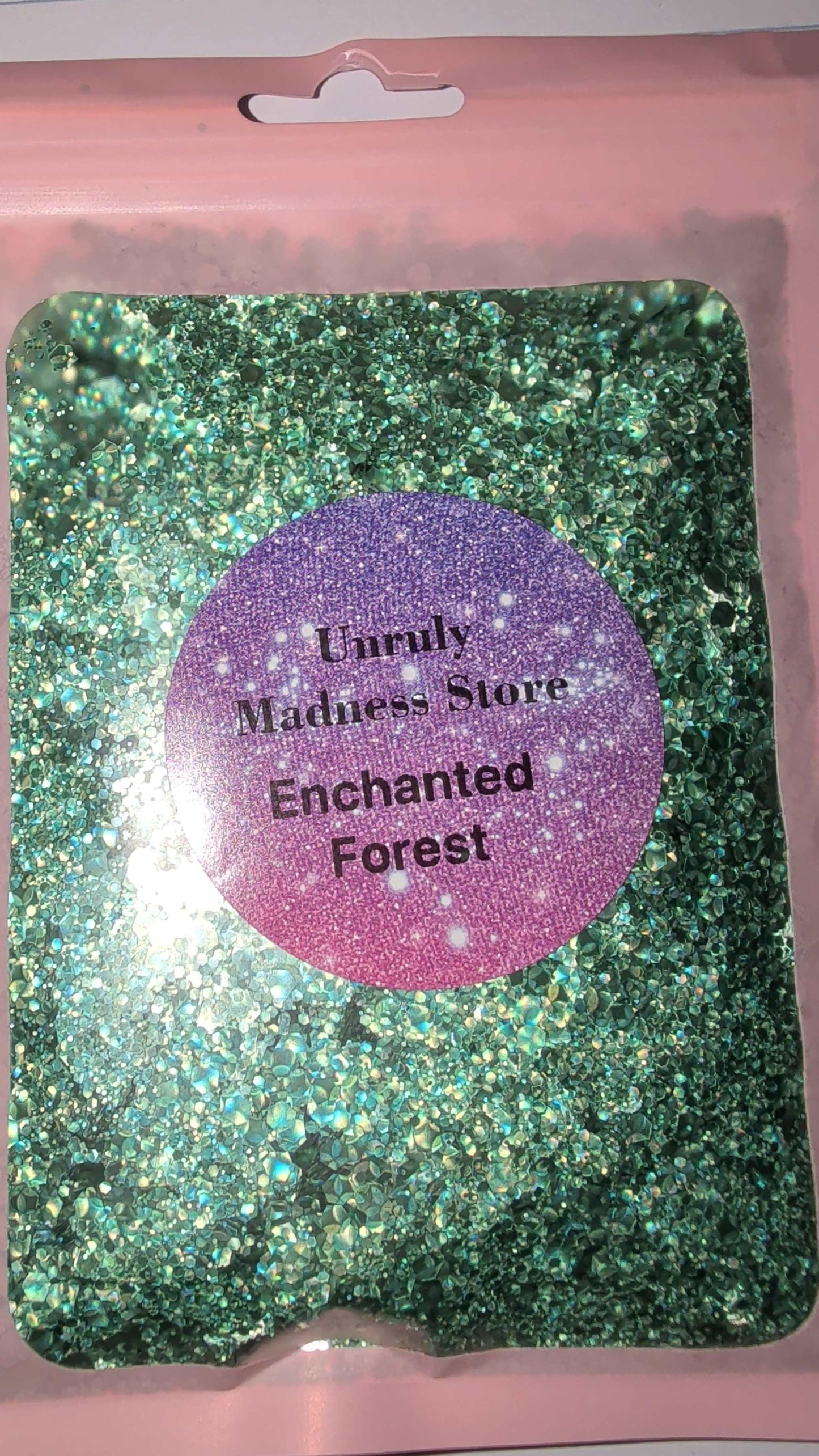 Enchanted Forest Glitter 2oz green polyester glitter in clear pouch with pink border and purple label